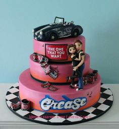 a pink cake with an image of a woman and a car on top that says the one thing i want