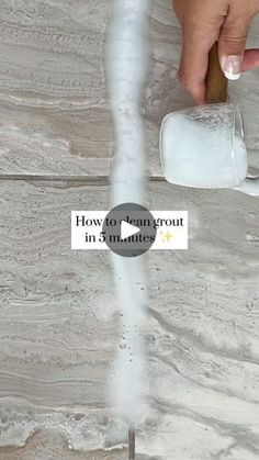 someone is pouring water into a glass on the floor with white foam in front of them