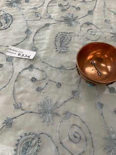 a metal bowl sitting on top of a table next to a price tag that says $ 25