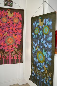 two wall hangings with flowers and birds on them