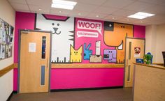 this is an office with pink walls and cartoon characters on the wall behind the doors