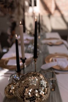 the table is set with candles, plates and napkins in mosaic style designs on it