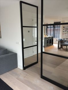 a living room filled with furniture and a large mirror on the wall next to a couch