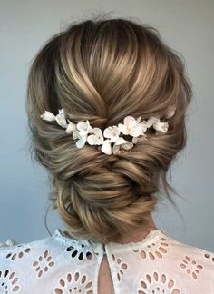 a woman with blonde hair and flowers in her hair is shown from the back view