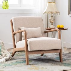 a living room area with a chair, table and lamp on the floor next to a window