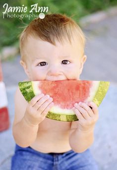 a baby is eating a piece of watermelon