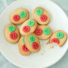 some cookies are on a white plate with green and red icing that says n