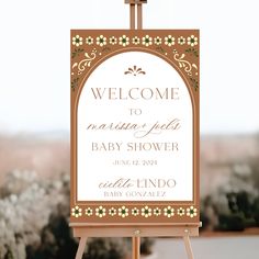 a welcome sign for a baby shower with flowers on it and a cross in the middle