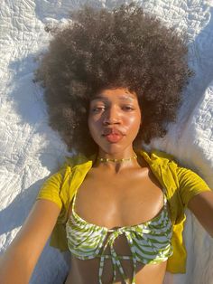 a woman laying in the snow with an afro