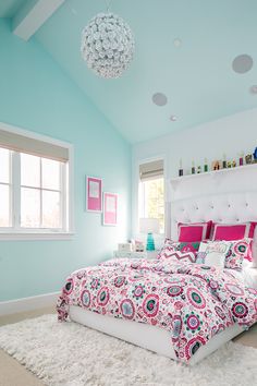 a bedroom with blue walls, white carpet and pink bedding in the center of the room