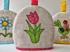 three bags with flowers and birds on them are lined up next to each other in different colors