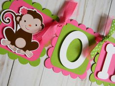 a pink and green banner with a monkey on it's name is hanging from the wall