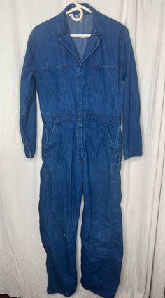 This jumpsuit is good used condition. There are some stains on the garment (pictured) and a few small holes. If you have any questions please feel free to ask. Flat Lay Measurements: Chest: 23 inches Shoulder: 18 inches Waist: 17 inches Hip: 20 inches Inseam: 29 inches Length: 59 inches Vintage Dark Wash Overalls, Vintage Cotton Denim Jumpsuit In Medium Wash, Vintage Dark Wash Shortalls With Pockets, Vintage Fitted Denim Jumpsuit Overall, Fitted Vintage Denim Jumpsuit, Vintage Dark Wash Overalls With Pockets, Vintage Dark Wash Cotton Denim Jumpsuit, Vintage Medium Wash Washed Overalls, Vintage Washed Cotton Overalls