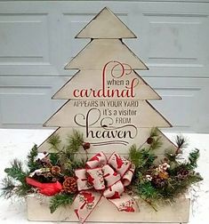 a wooden christmas tree with red and white bows