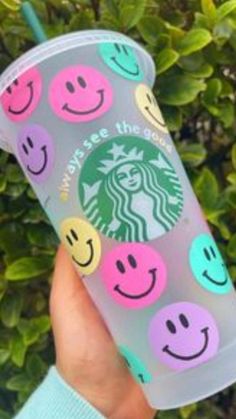 someone holding up a starbucks cup with smiley faces on it