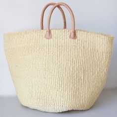 Sisal is a flowering plant that has been cultivated and naturalized in Kenya, and the strong fibers that come from it are used to make various items from rope to bags. These durable baskets can handle a heavy load without breaking a sweat while looking handsome at the same time! Woven from natural sisal plant fibers with leather handles. A Kenyan market artisan partnership. Learn more about our artisans' handmade products here. Details: 14" T 20" W Large 12" T 18" W Medium Colors and designs var Beige Basket Bucket Bag With Rolled Handles, Natural Bucket Bag With Braided Handles For Market, Beige Basket Beach Bag With Rolled Handles, Natural Basket Beach Bag With Rolled Handles, Natural Straw Basket Bag With Rolled Handles, Natural Basket Straw Bag With Rolled Handles, Natural Basket Bag With Rolled Handles, Natural Basket Crochet Bag For Market, Natural Crochet Basket Bag For Market