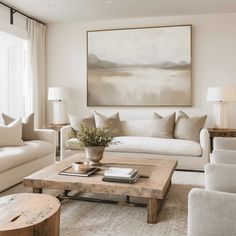 a living room filled with furniture and a large painting on the wall above it's coffee table