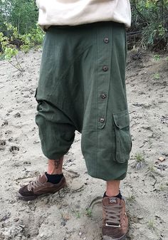 green bloomers out of heavy cotton fabric ॐ with two baggy bags and one regular pocket on the right leg. on the left leg is a raw of wooden buttons. it has an elastical waist band so it fits on perfect to your body. with the elastic bands on the ankles you can wear it as a short or 3/4 pants visually, this harem pants fits wonderfully with everything that is psychedelic, whether it's hippie, goa or psytrance parties, but also for yoga or meditation as well as in everyday life - with these comfor Green Parachute Pants For Summer Outdoor, Green Parachute Pants For Outdoor Summer, Baggy Hippie Harem Pants With Pockets, Baggy Green Parachute Pants For Summer, Baggy Green Hippie Harem Pants, Baggy Green Pants For Festival, Green Baggy Harem Pants In Hippie Style, Baggy Cotton Cargo Pants For Festival, Green Baggy Pants For Festival