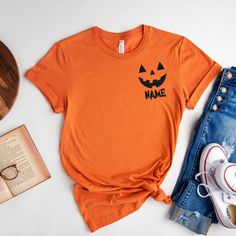 Custom Halloween Shirt, Pocket Size Halloween Shirt, Halloween Party Tee, Halloween T-shirt, Halloween Pumpkin Shirt, Matching Halloween How to Order?  1-Choose your t-shirt color, 2- Choose your size, 3- Select the quantity, 4- Click Add to Cart.  Production and shipping: * 100% airlume combed and ring-spun cotton, 32 singles 4.2 oz. * Solid colors are %100 cotton * Heathers are %52 cotton %48 polyester * Athletic Heather is combed and ring-spun cotton, 10% polyester * Seamless collar * Heat tr Orange Halloween T-shirt With Letter Print, Fun Halloween Short Sleeve Shirt, Spooky Short Sleeve Orange Shirt, Spooky Orange Crew Neck T-shirt, Orange Crew Neck Top For Halloween, Halloween Short Sleeve Shirt With Direct Printing, Halloween Orange Crew Neck T-shirt, Orange Letter Print Shirt For Halloween, Fun Halloween T-shirt Pre-shrunk