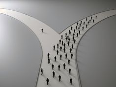 a group of people walking across a long white bridge with one person on the other side