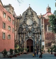 two people walking in front of an old building