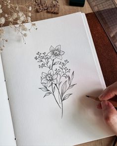 a person is drawing flowers on paper