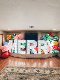 a room with balloons and letters that spell merry