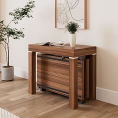 a wooden table with a potted plant next to it on top of a hard wood floor