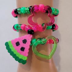 These kandi bracelets are made with glitter pink,green and black pony beads and cute charms. These are made in all different sizes. One size fits most. Perfect for any event! You will get lots of compliments in this unique wearable art! Stand out at your next event! Edm festival  Raves Party  Rave outfit  Festival outfit Pride Party favors  Birthday gifts Stocking stuffer  Rave anniversary  Rave gift Handmade Green Heart-shaped Bracelet, Kawaii Pink Bracelet For Party, Playful Plastic Dangle Jewelry, Pink Novelty Plastic Bracelets, Pink Plastic Novelty Bracelets, Cute Plastic Stretch Bracelet As Gift, Fun Festival Jewelry With Round Beads, Novelty Green Beaded Bracelets, Cute Plastic Stretch Bracelet Gift