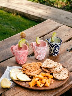 a plate with crackers, crackers and cheese on it sitting on a picnic table