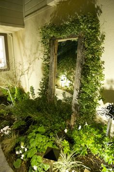 a mirror sitting in the middle of a garden