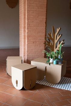 two cardboard boxes sitting on top of a tiled floor next to a planter and mirror