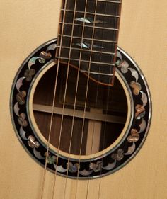 a close up of an acoustic guitar's frets and strings with designs on it