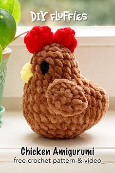 a crochet chicken sitting next to a potted plant on a window sill