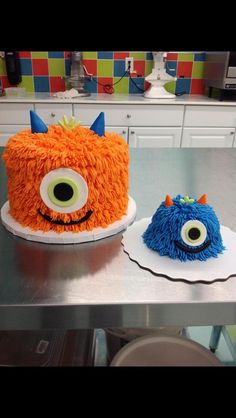 two cakes made to look like monsters sitting on top of a counter