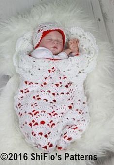 a baby wrapped in a white crochet blanket