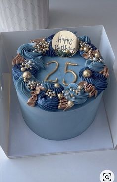 a blue birthday cake in a box with the number twenty five on it's side