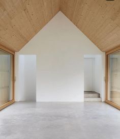 an empty room with wooden walls and windows