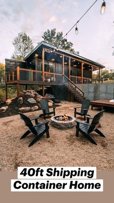 a fire pit sitting in the middle of a yard next to two chairs and a deck