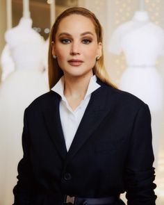 a woman standing in front of mannequins with her hands on her hips