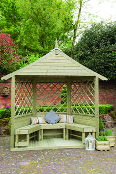 a wooden gazebo sitting in the middle of a garden