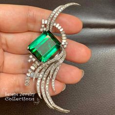 One of our favorite pieces in our collection, a stunning large green tourmaline is set in platinum and an elegant wispy arrangement of diamonds flows around!  Total Weight: 23 grams Size: 3 inch x 1 inch Precious Metal: Platinum Precious stones: -Green tourmaline: 19.1mmx15.8mm, 41 carats -White Round Diamonds: 5.5 carats Hallmark: Plat Luxury Green Brooches For Wedding, Elegant Green Diamond Brooch, Luxury Green Brooch Jewelry, Luxury Green Brooches For Anniversary, Luxury Green Brooch For Anniversary, Luxury Green Brooch For Formal Occasions, Elegant Green Gemstone Brooches, Elegant Green Gemstone Brooch, Elegant Green Brooches For Formal Occasions