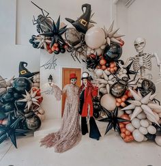 two people standing in front of halloween decorations