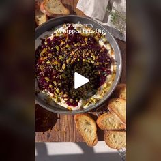 a bowl filled with food sitting on top of a table next to bread and butter