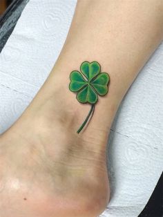 a green four leaf clover tattoo on the foot