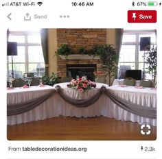 the table is set up for an event with flowers and greenery in vases