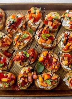 a wooden tray topped with lots of different types of appetizers on top of each other