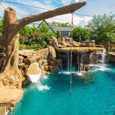 an outdoor pool with waterfall and water features