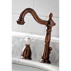 a faucet that is sitting on top of a sink in a bathroom with marble counter tops