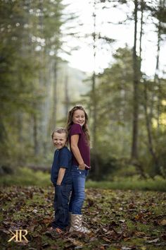 two children are standing in the woods together